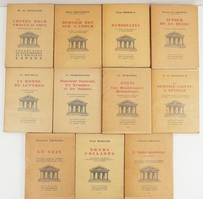 six books on a table with a white wall in the background