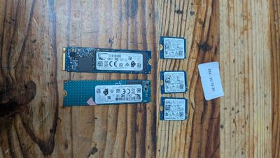 deux disques SSD et un disque dur posés sur une table en bois