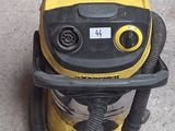 un aspirateur jaune et noir posé sur le trottoir