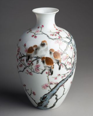 un vase blanc orné d'une peinture représentant des oiseaux et des fleurs