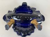 a blue glass vase with two gold handles on it