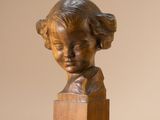 bronze bust of a young girl on a wooden base