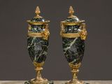 a pair of green marble urns with gold accents