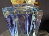an image of a blue glass perfume bottle sitting on top of a table