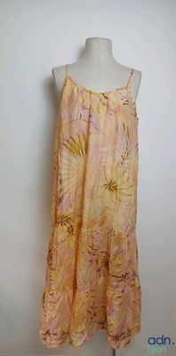 a woman ' s dress on a mannequin stand against a white wall