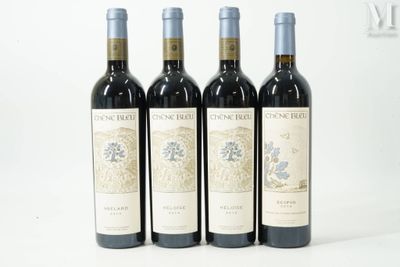 trois bouteilles de vin rouge sont alignées sur une surface blanche