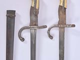 two old swords are displayed on a white surface with a white background