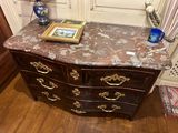 a marble top chest of drawers with a picture on top