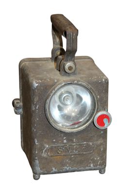 un petit objet métallique muni d'un bouton rouge