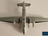 a silver model of a plane on a white surface