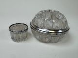 a glass container with a silver lid next to a glass cup
