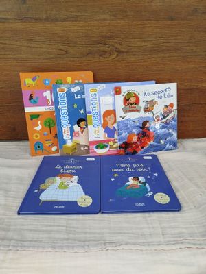 three children ' s books sitting on a bed with a wooden headboard