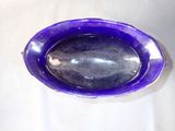a purple glass bowl with a spoon inside of it