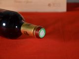 a bottle of wine sitting on a red table cloth