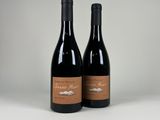 deux bouteilles de vin posées sur une table blanche