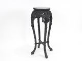 une table noire avec un plateau en marbre posée sur une surface blanche