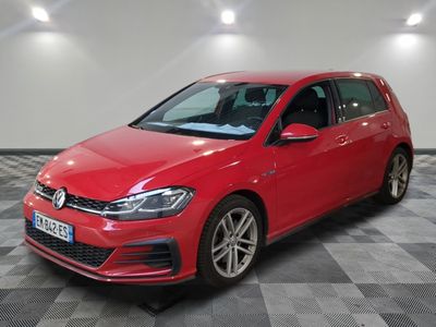 a red volkswagen golf is parked on a checkered floor