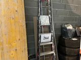 une échelle appuyée contre un mur, à côté d'un tas de pneus