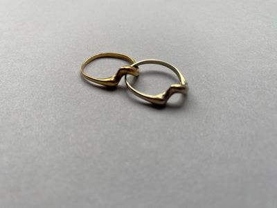 deux bagues en or posées l'une sur l'autre sur une table