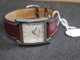 une montre posée sur une table à côté d'une étiquette