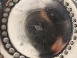 a close up of a silver vase with holes in it