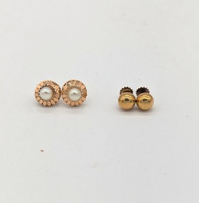 une paire de boucles d'oreilles en or et perles posées sur un fond blanc