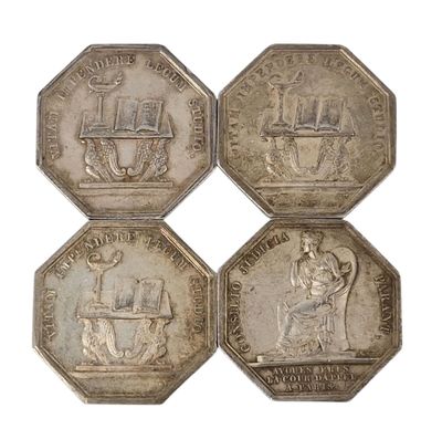 quatre pièces d'argent de tailles et de formes différentes sur un fond blanc