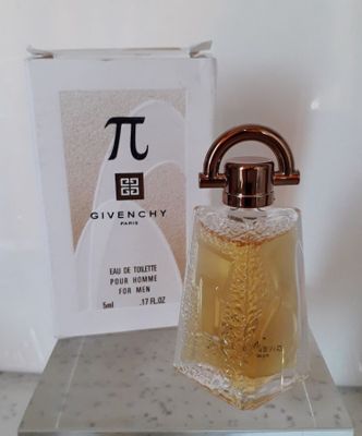 Un flacon de parfum Givenchy et son coffret posés sur un comptoir, avec une boîte de parfum en arrière-plan
