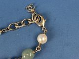 bracelet with pearls and a cross on a blue background