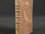 an old book sitting on top of a black surface