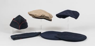 several hats and mitts are sitting on a stand on a white surface