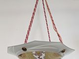 a white bowl hanging from a rope on a white wall