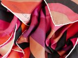 the scarf is multicolored and has a black, pink, orange, and red stripe