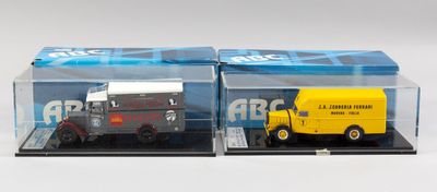 deux camions miniatures dans une vitrine posée sur une surface blanche