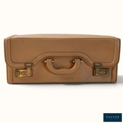 une valise beige posée sur une surface blanche, avec un fond blanc