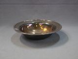 a silver bowl sitting on a table with a gray background