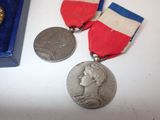two medals are sitting on a table next to a blue box