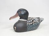un canard posé sur une surface blanche