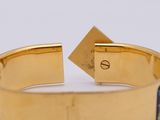 a close up of a gold cuff with a blue and white design