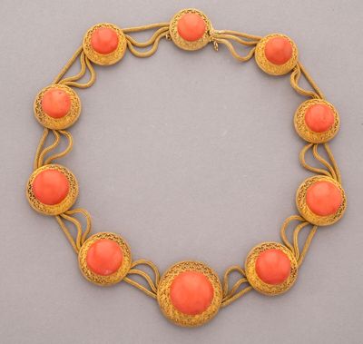 un bracelet aux couleurs or et corail