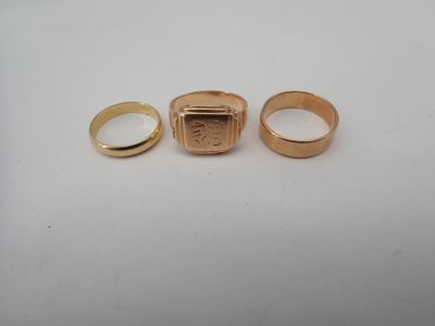 two gold rings and a ring with a picture of a man ' s face on it