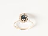 une image représentant une bague ornée d'une pierre bleue entourée de diamants blancs