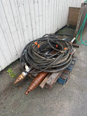 un tas de tuyaux et un tuyau d'arrosage par terre