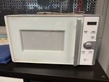 a white microwave sitting on top of a black table