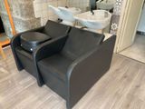 une chaise noire et un lavabo blanc dans une pièce