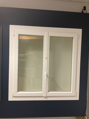 une photo d'une salle de bains avec des toilettes et une fenêtre