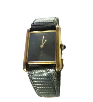 une image représentant une montre noire et dorée au cadran carré