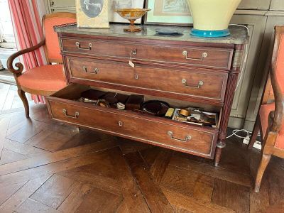 une commode dans un salon, sur laquelle est posé un vase