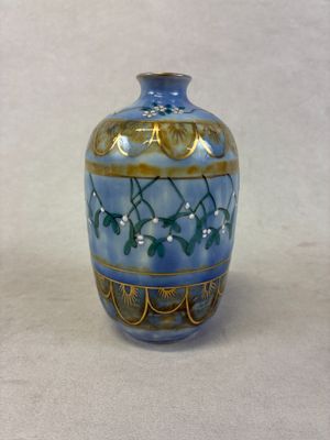 a blue and gold vase sitting on a white surface