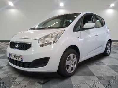 the small white car is parked in a large room
